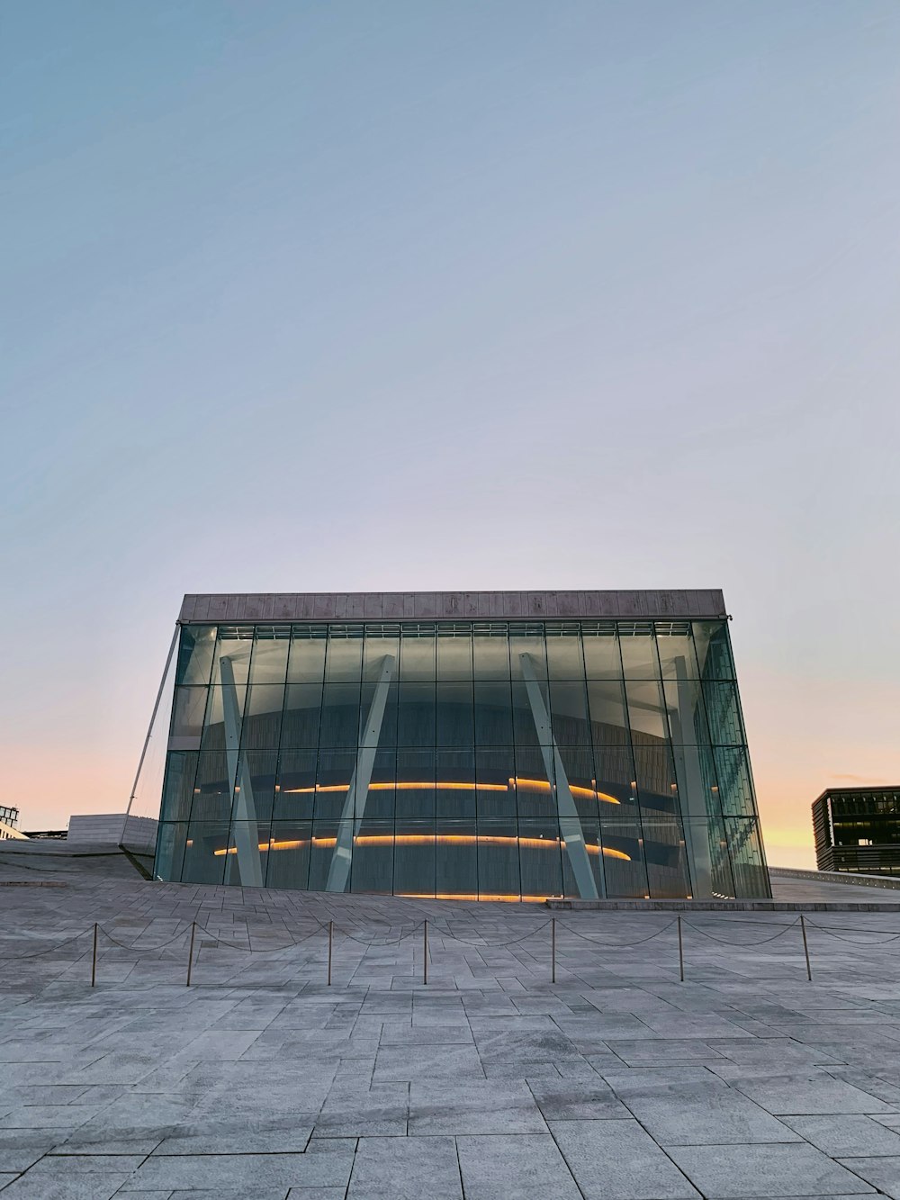 a large glass building sitting on top of a cement field