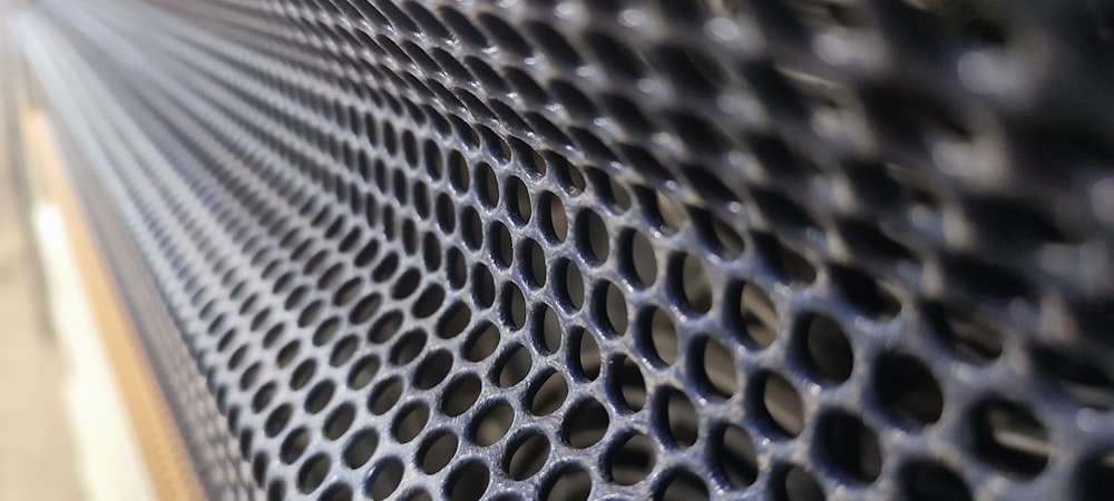 a close up of a metal surface with holes