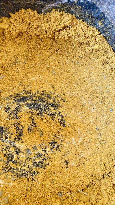 Close-up of dark, fine humic acid powder spilling from a burlap sack.