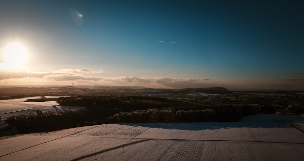 o sol está brilhando sobre um campo nevado