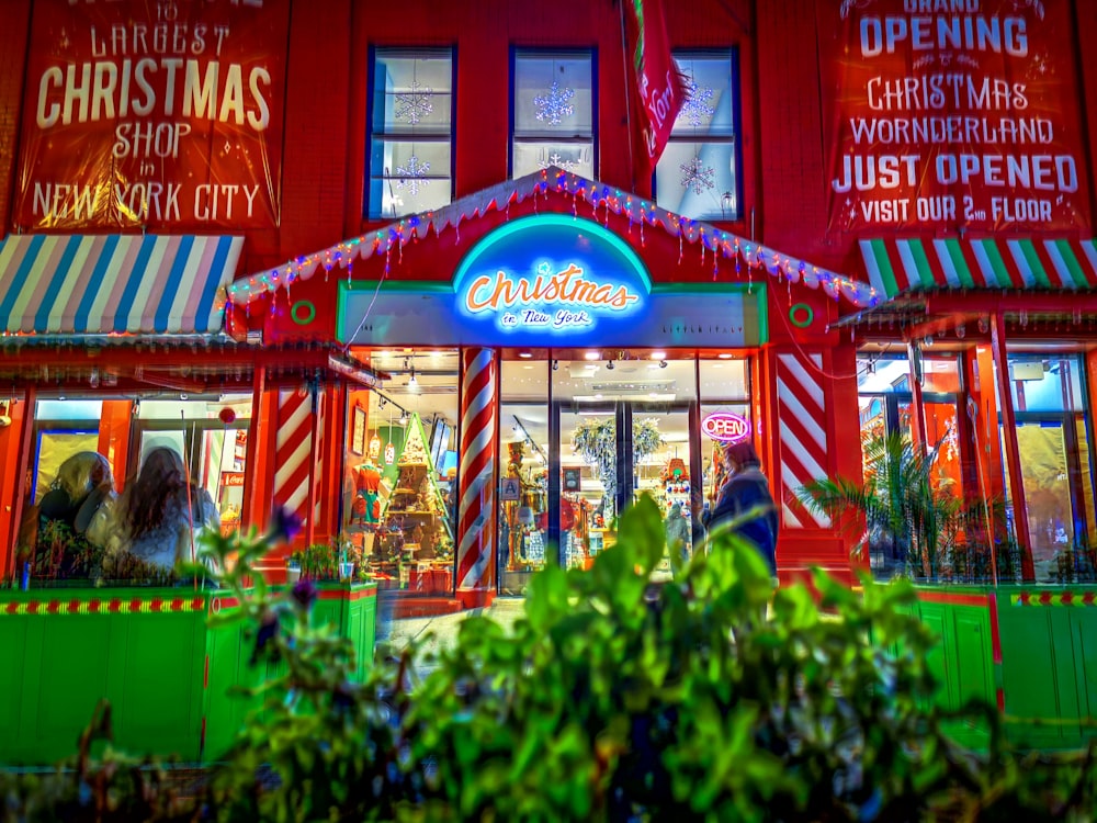 a brightly lit christmas store front at night