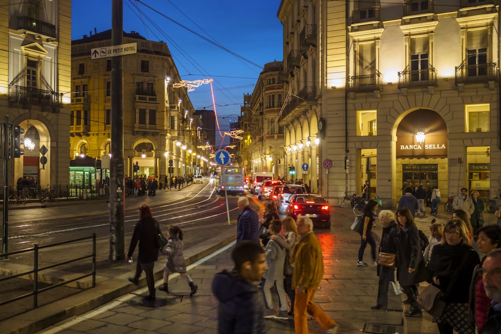 um grupo de pessoas andando por uma rua ao lado de edifícios altos