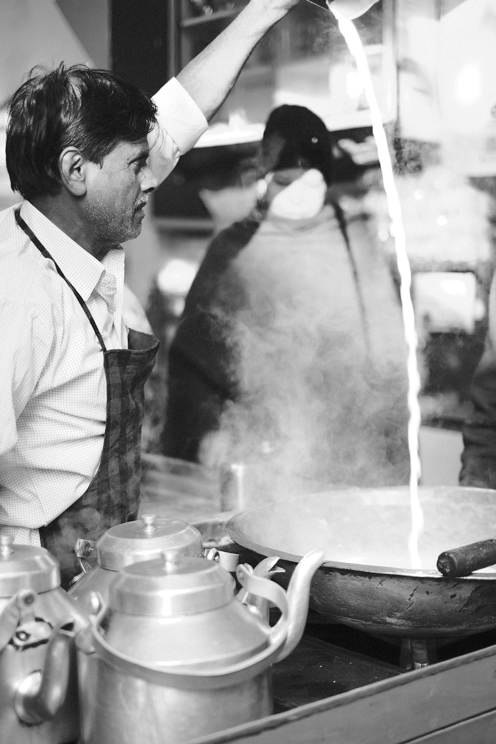 a man is cooking on a stove in a kitchen