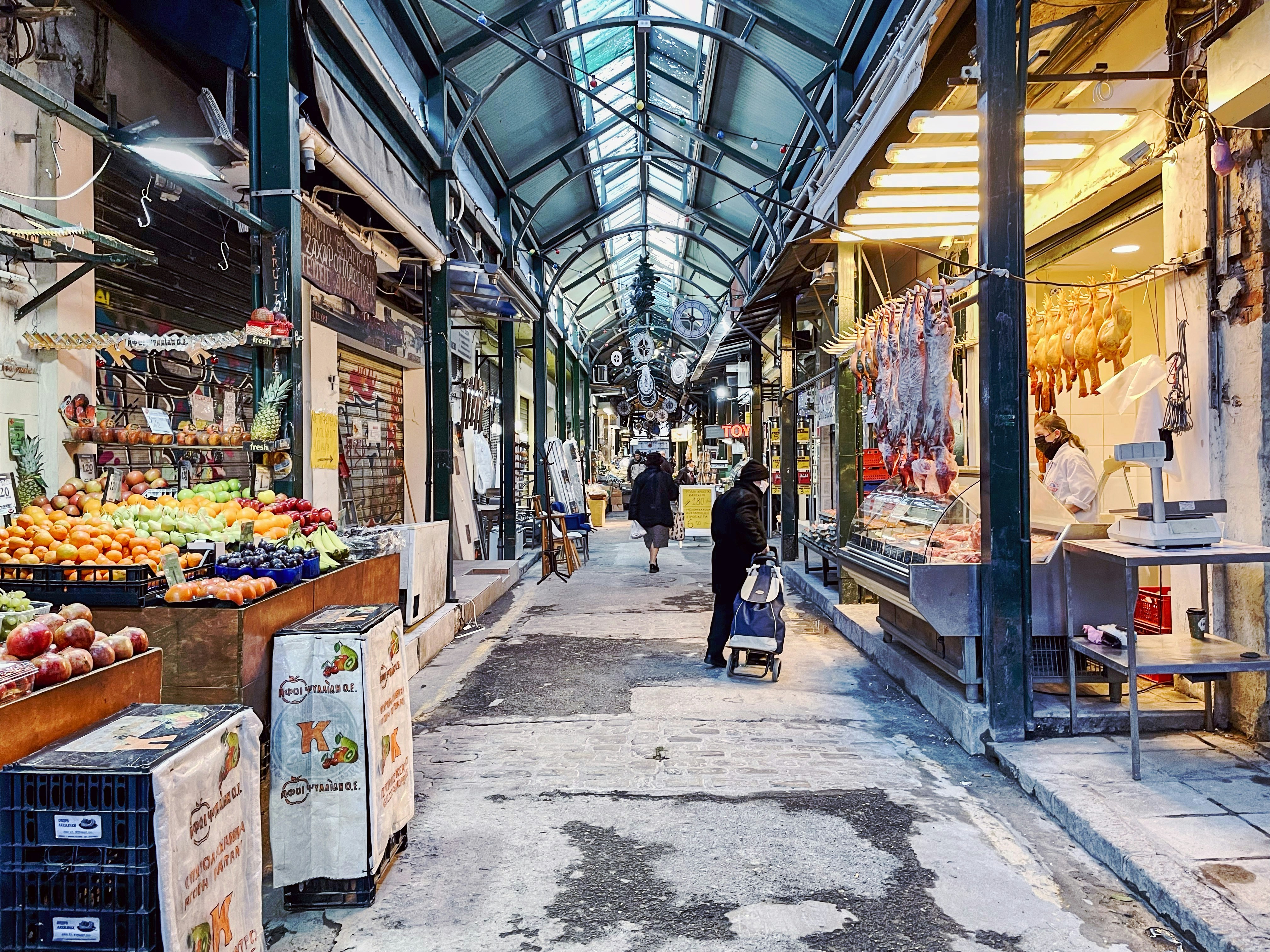 a man walking down a street next to a market