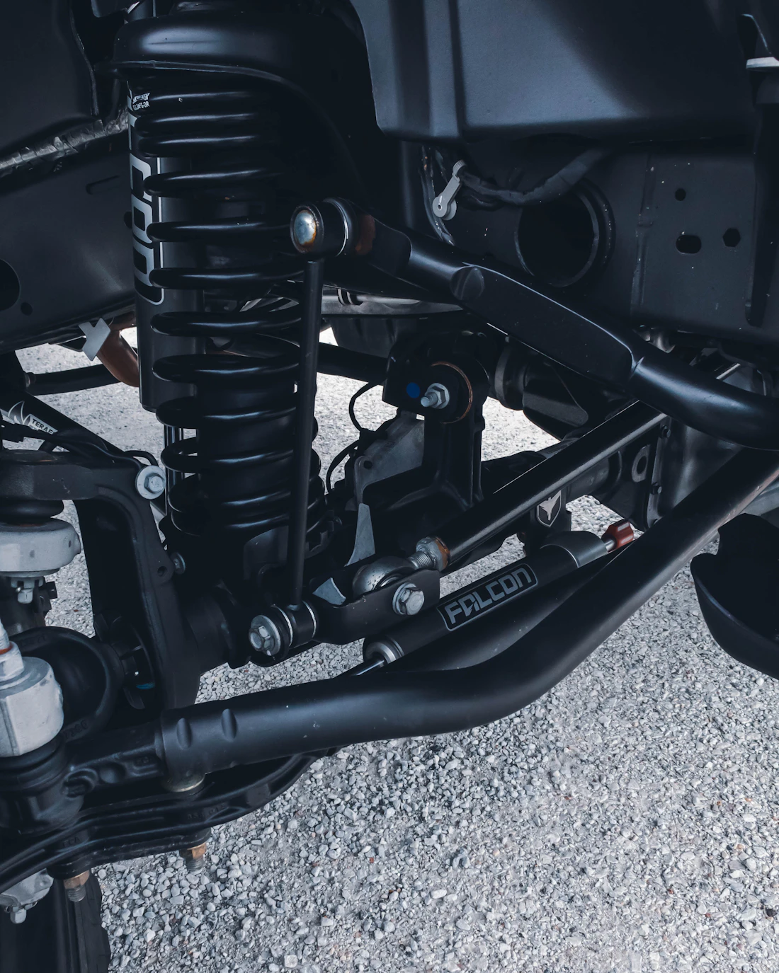 Underside view of a vehicle's suspension and control arm during a repair