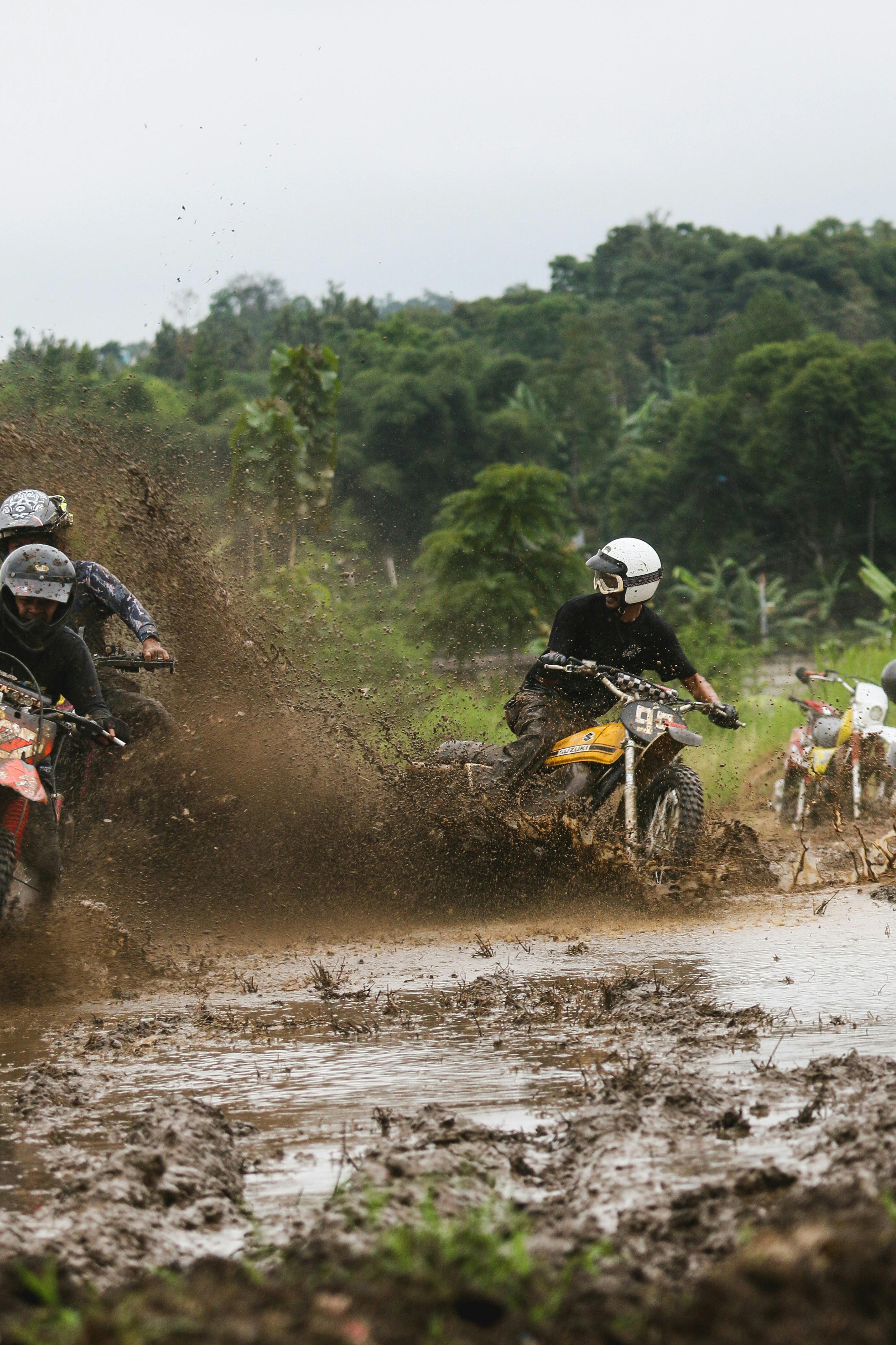 a couple of people riding on the back of dirt bikes