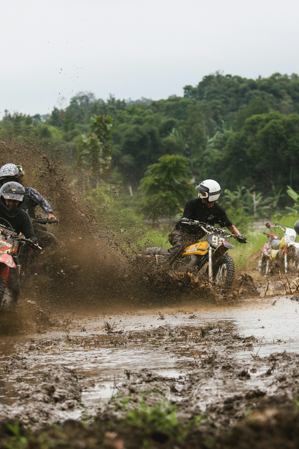 a couple of people riding on the back of dirt bikes