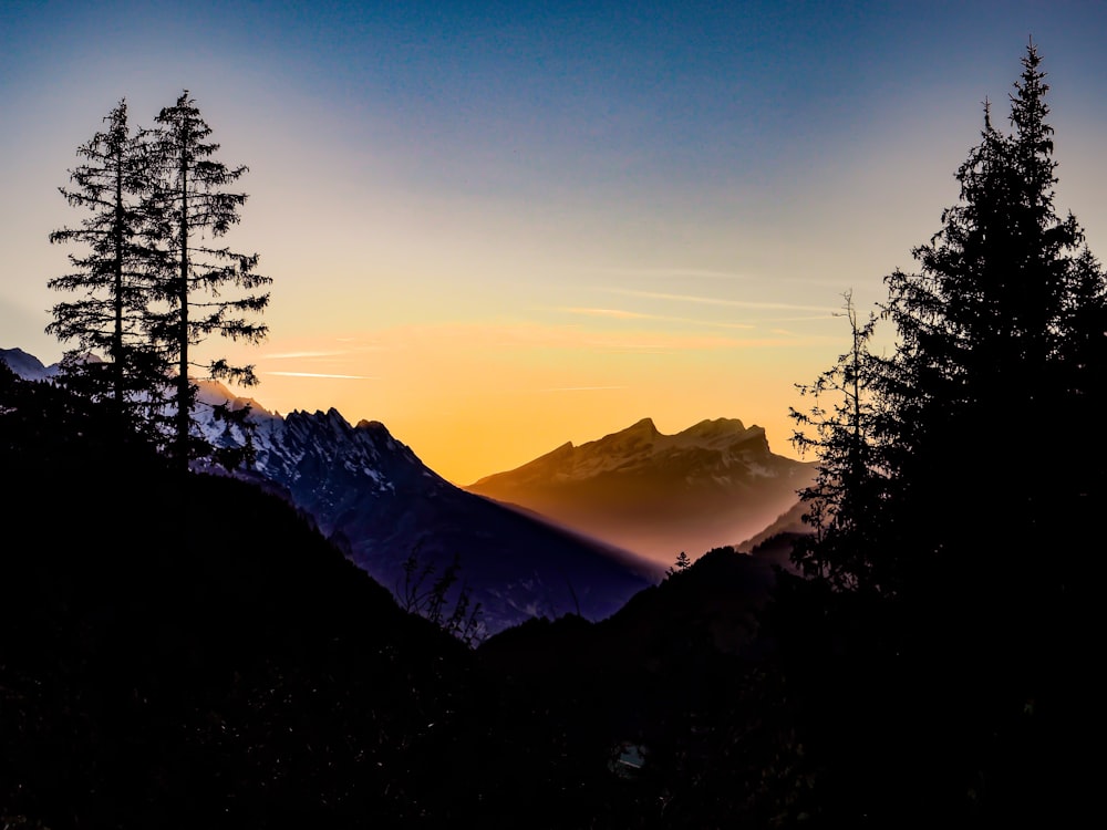 the sun is setting over a mountain range