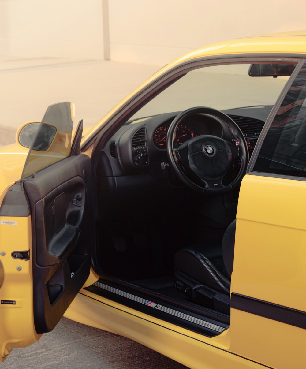 the interior of a yellow sports car with its door open