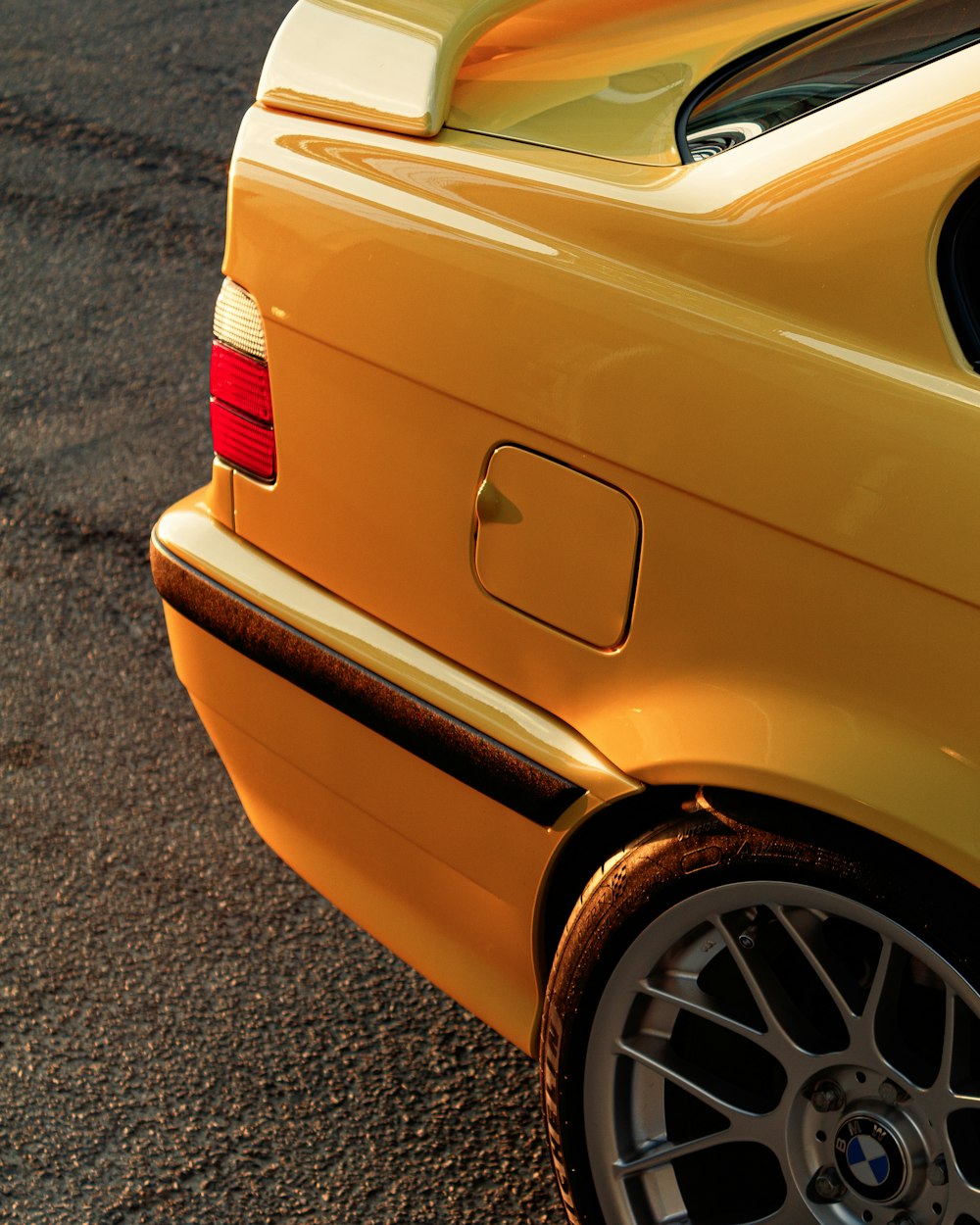 a close up of the rear end of a yellow car