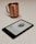 A Kindle e-reader displays a page from a book, laid on a light-colored speckled countertop. In the background, a copper-colored mug with a handle is slightly out of focus.