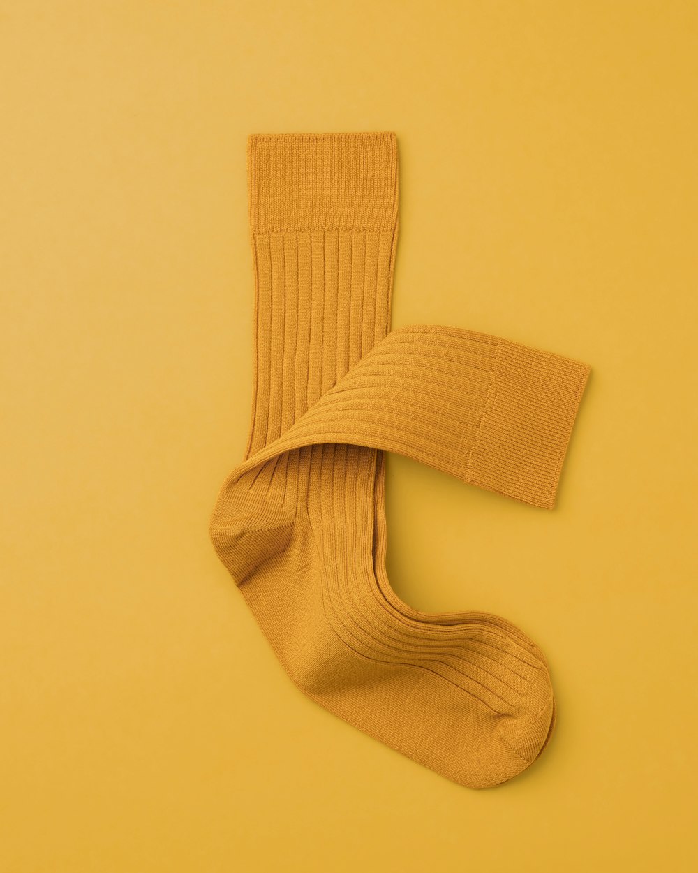 a pair of socks laying on top of a yellow surface