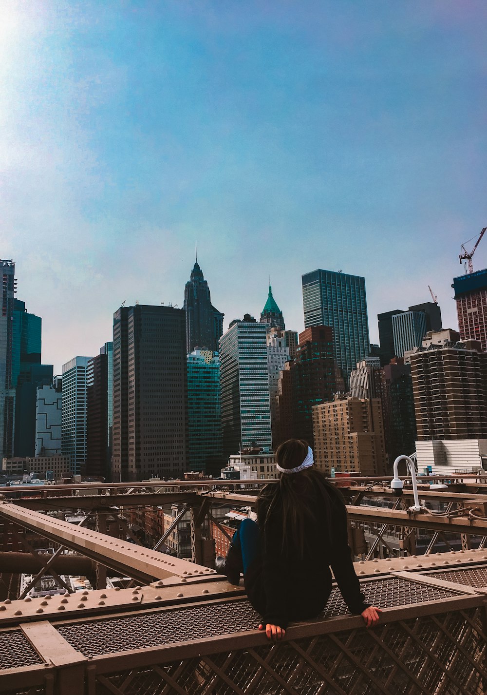 a person standing on a bridge with a city in the background