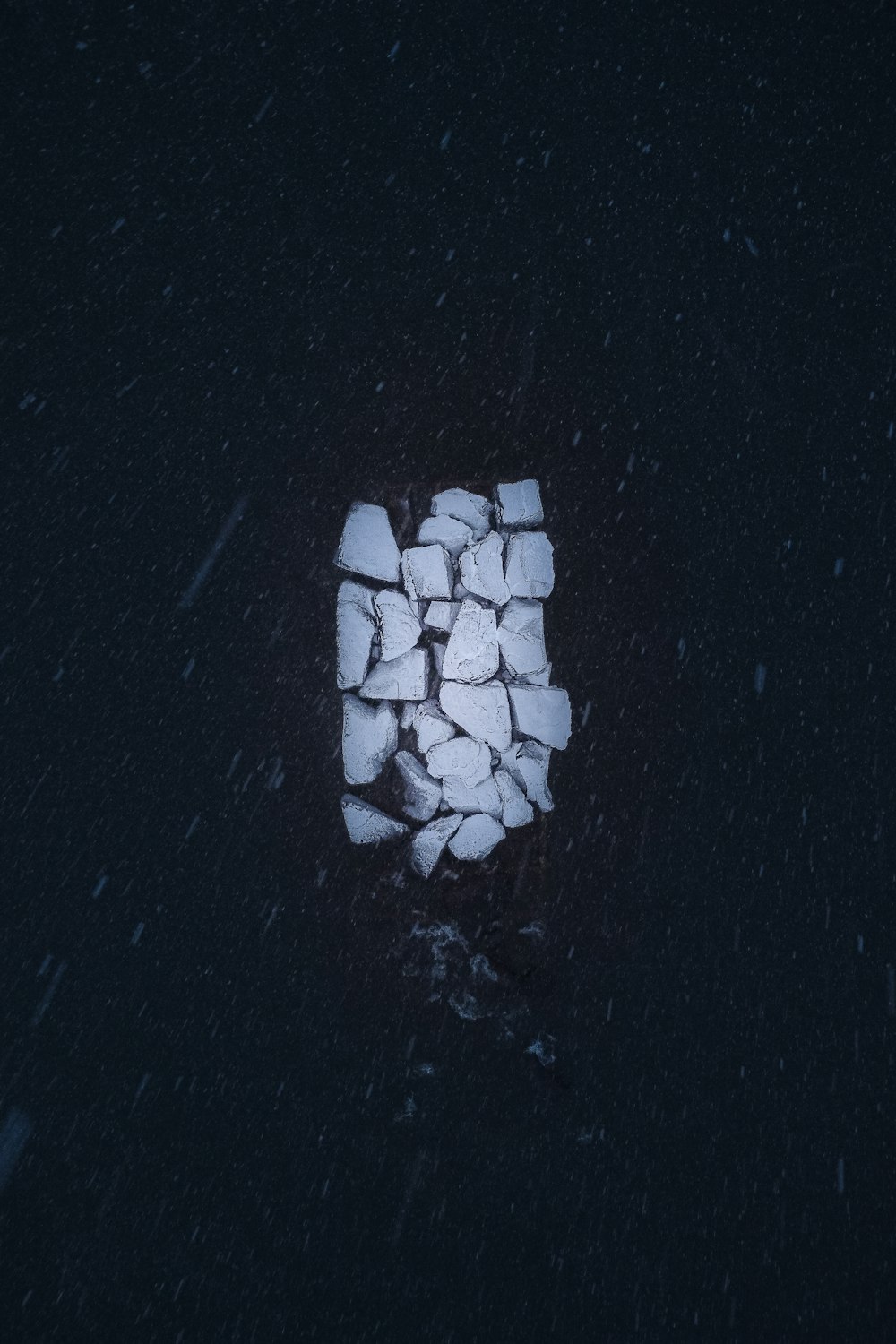 a pile of ice cubes sitting on top of a black surface