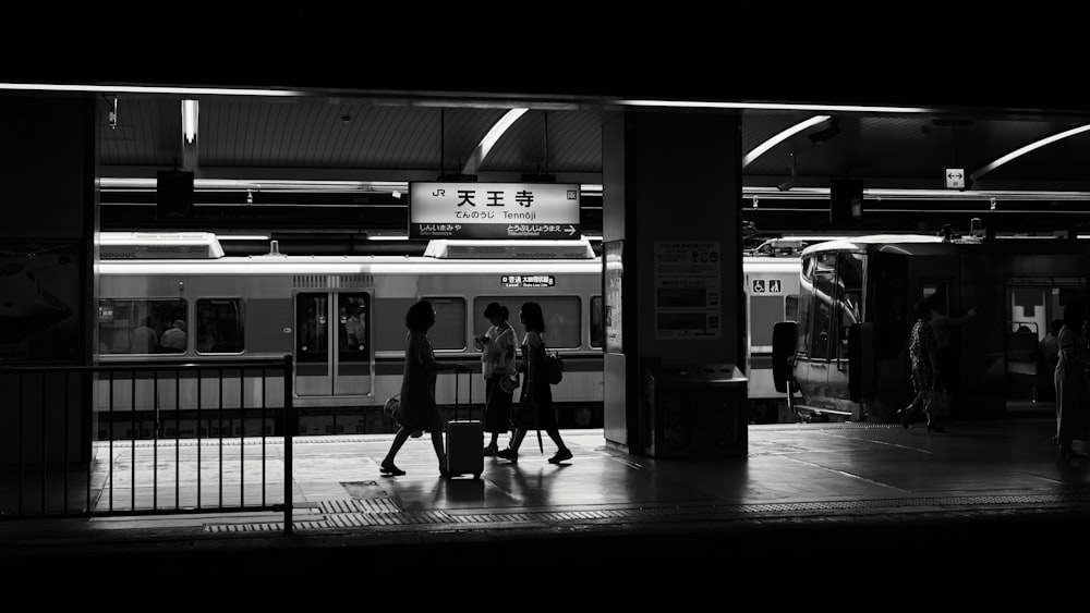 a couple of people that are standing next to a train