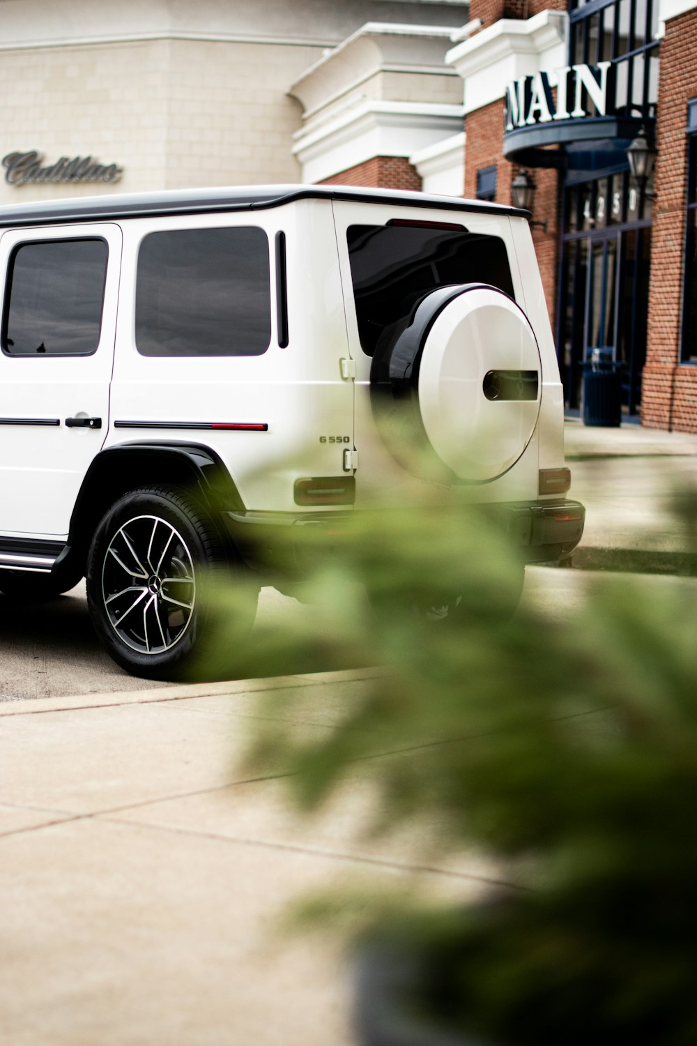 a white suv parked in front of a building