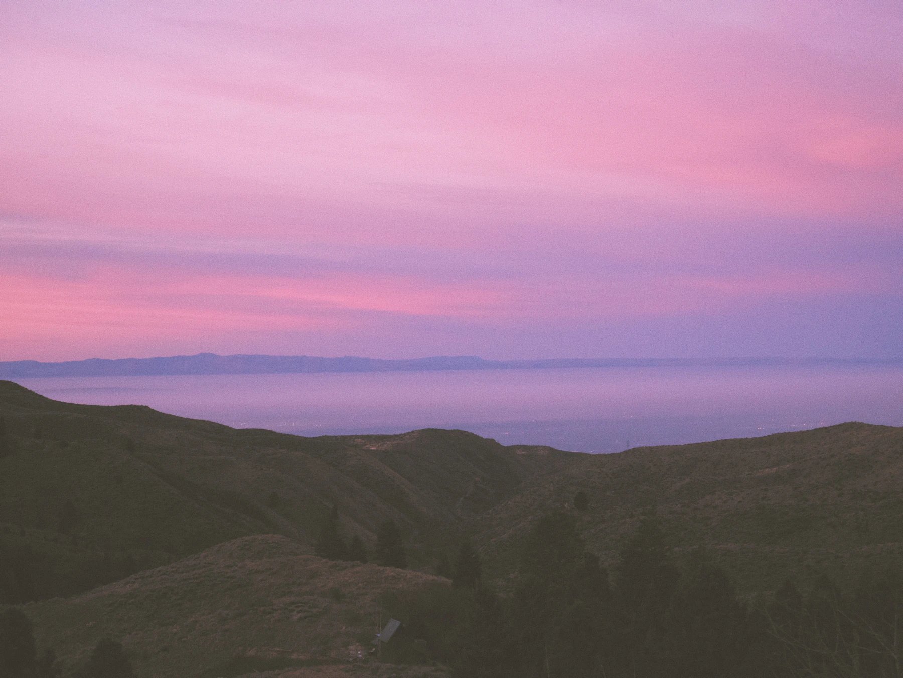 Soft pink and gold light over a mountain range