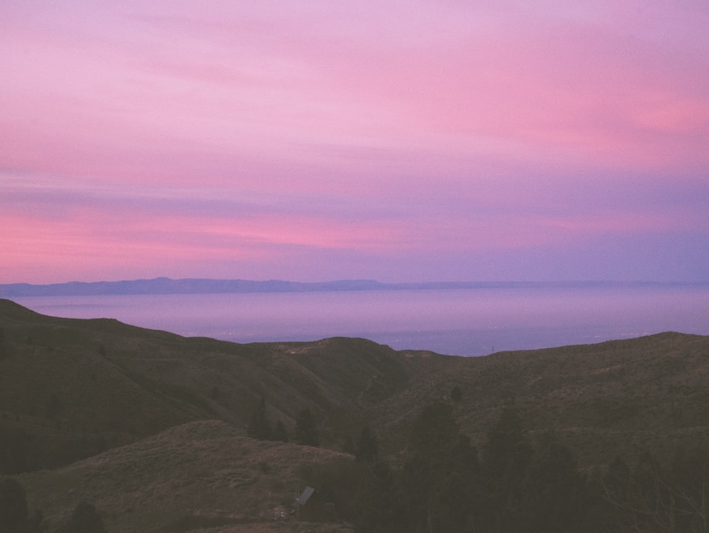 a pink and purple sky over a mountain range