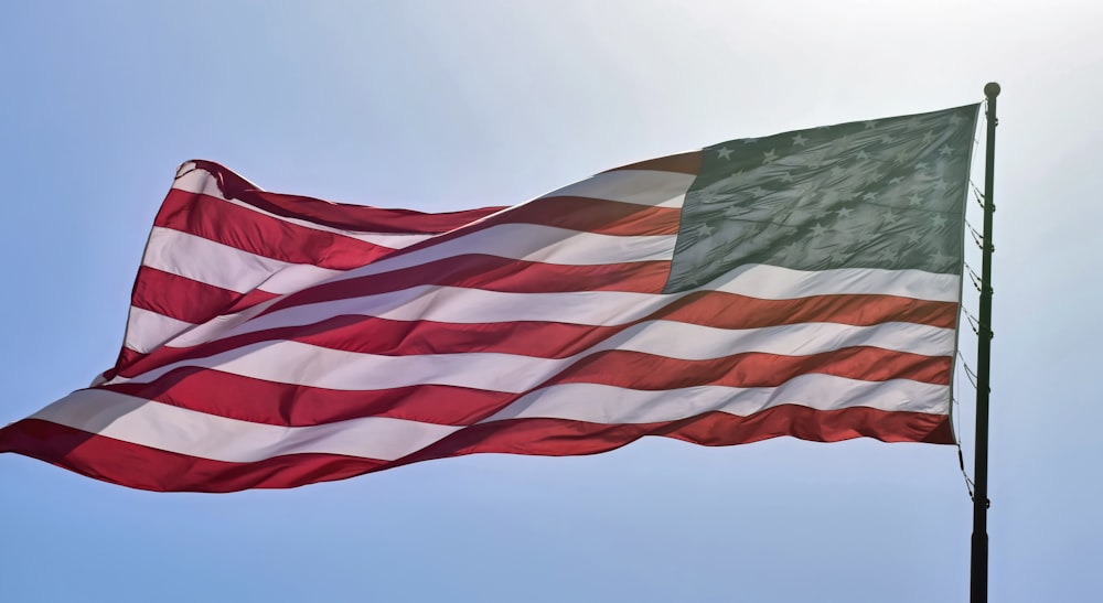 a large american flag flying in the sky