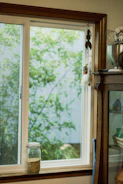 Sunlit kitchen corner with minimalist farmhouse decor and fresh herbs on the windowsill.