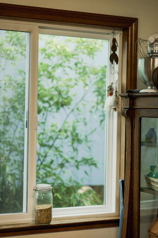 A cozy farmhouse kitchen with jars of homemade preserves and fresh herbs on the windowsill.