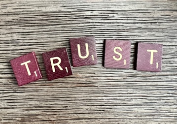 trust spelled with wooden letter blocks on a table