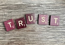 trust spelled with wooden letter blocks on a table