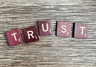 trust spelled with wooden letter blocks on a table