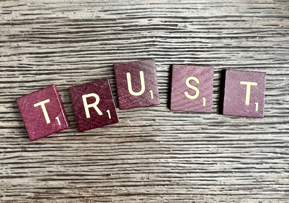 trust spelled with wooden letter blocks on a table