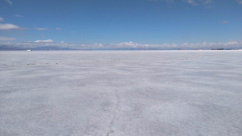 a vast expanse of snow with a blue sky in the background