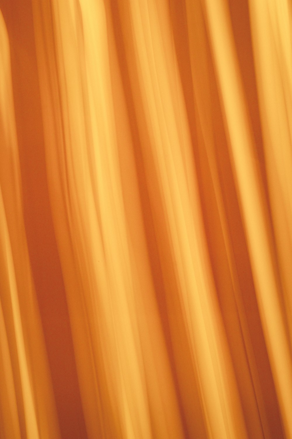 a blurry photo of a yellow curtain