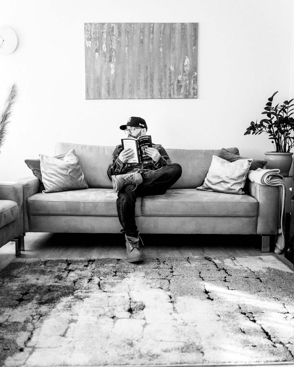 a man sitting on top of a couch holding a book