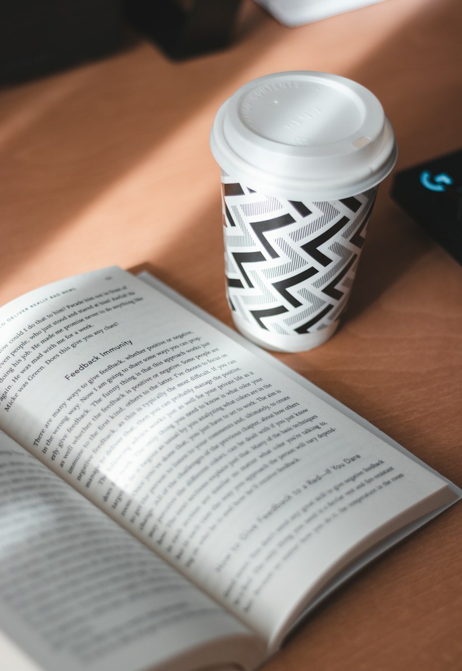 Open book and a coffee cup on a wooden desk
