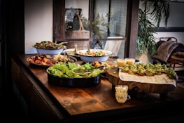 A rustic wooden table displaying a variety of homemade dishes ready to serve.
