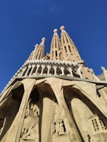 The historic Sagrada Familia basilica in Barcelona under a bright blue sky.