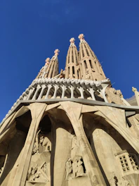 Visitors admiring the intricate façade of Sagrada Família illuminated by golden hour light.