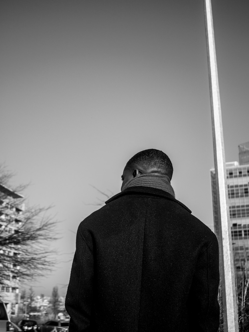 a man standing next to a tall pole