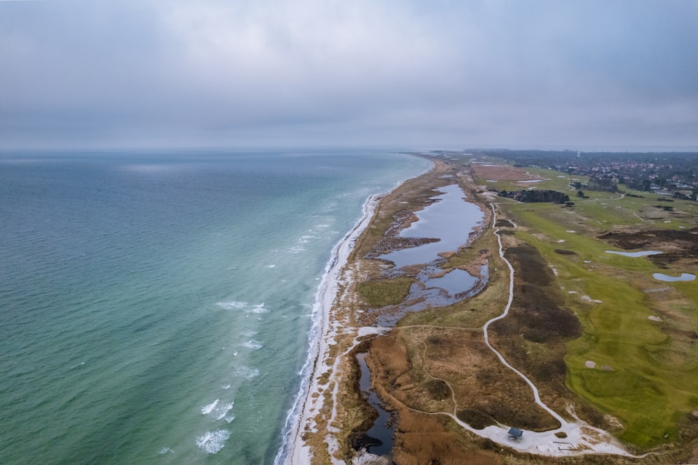 uma vista aérea de um campo de golfe ao lado do oceano