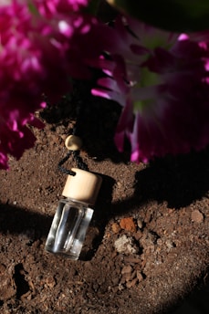 Close-up of a handcrafted herbal tincture bottle surrounded by fresh herbs and natural soil.