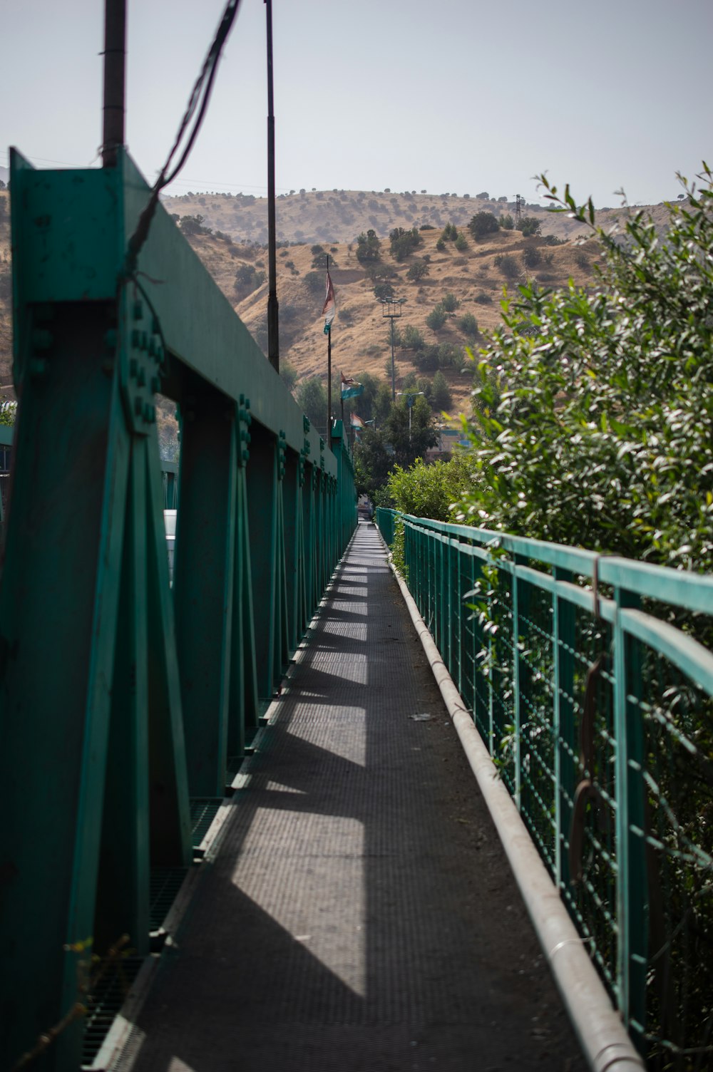 a green bridge with a person walking across it