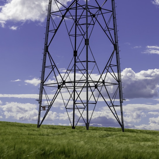 a tall metal tower sitting on top of a lush green field