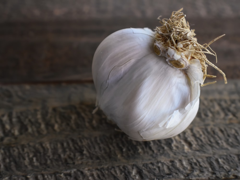 a close up of a garlic on a wooden surface