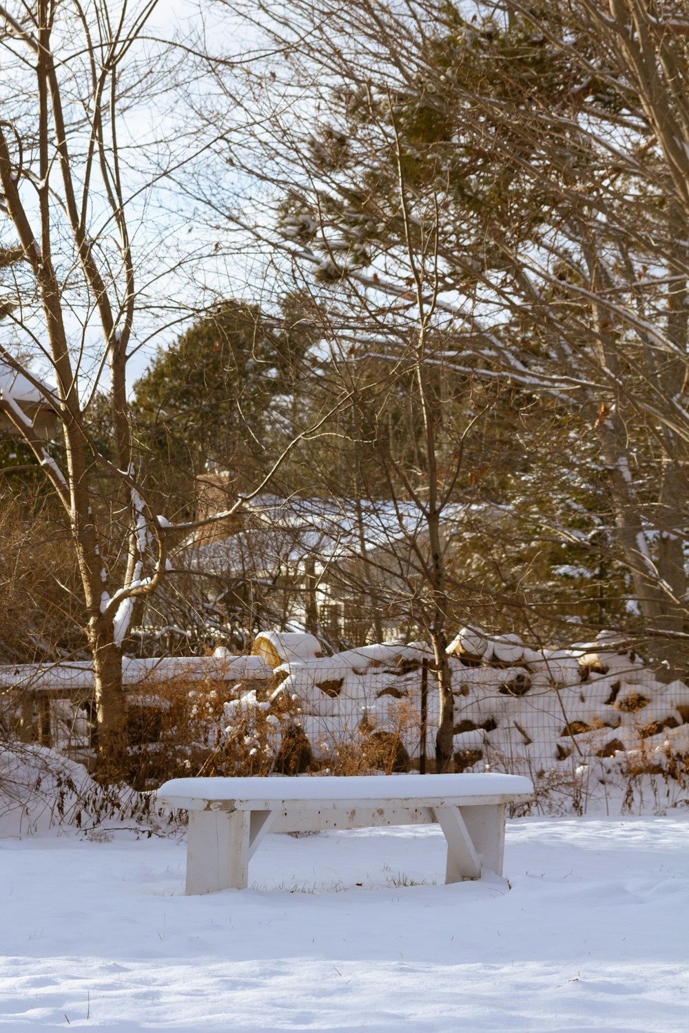 a white bench sitting in the middle of a snow covered field