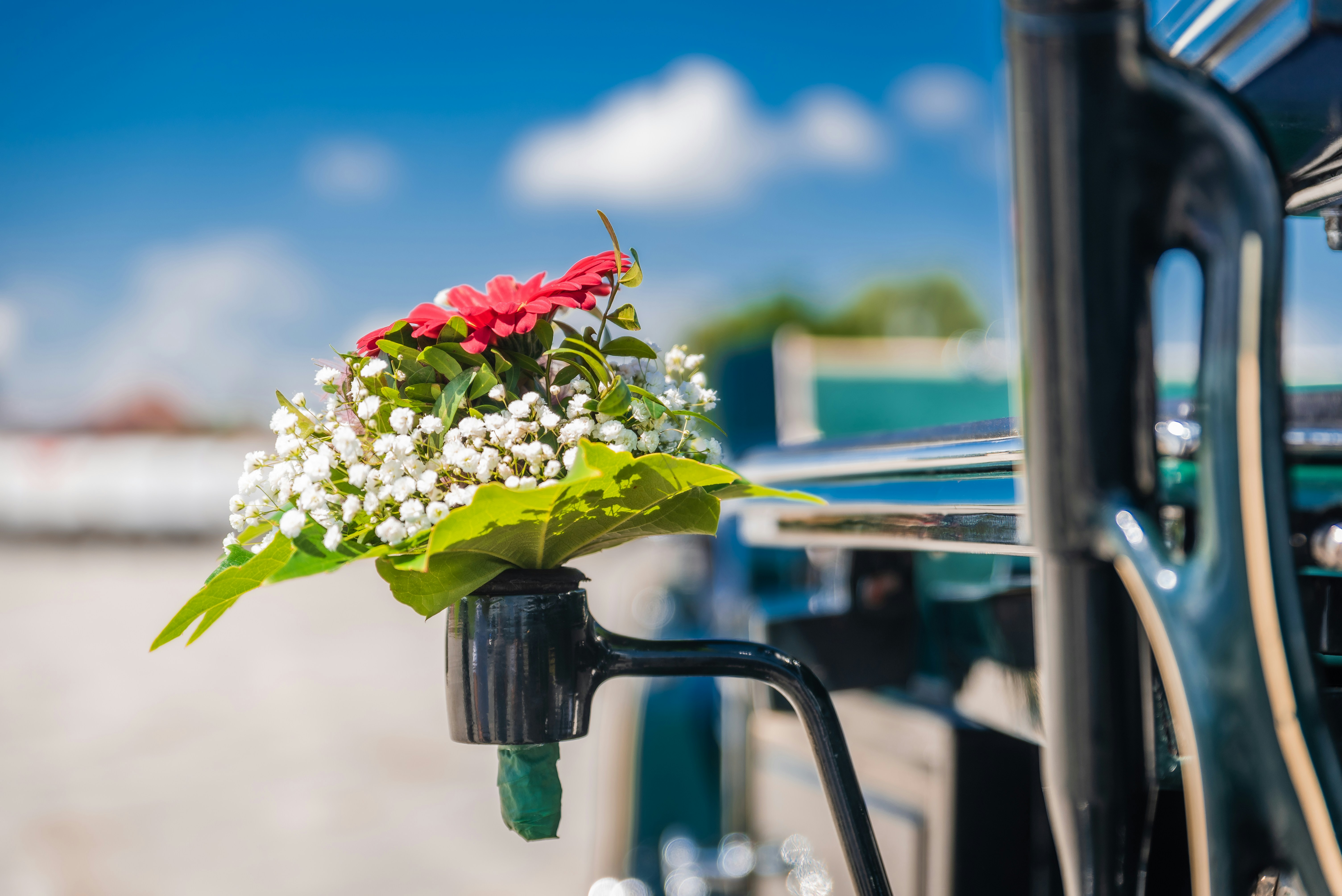 a bouquet of flowers sitting on the handle of a bus