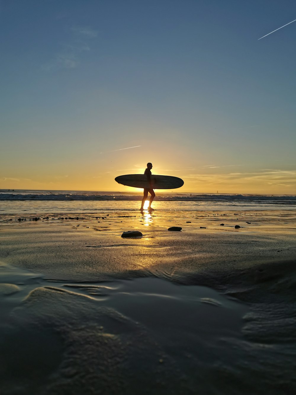 Ein Mann, der ein Surfbrett auf einem Strand hält