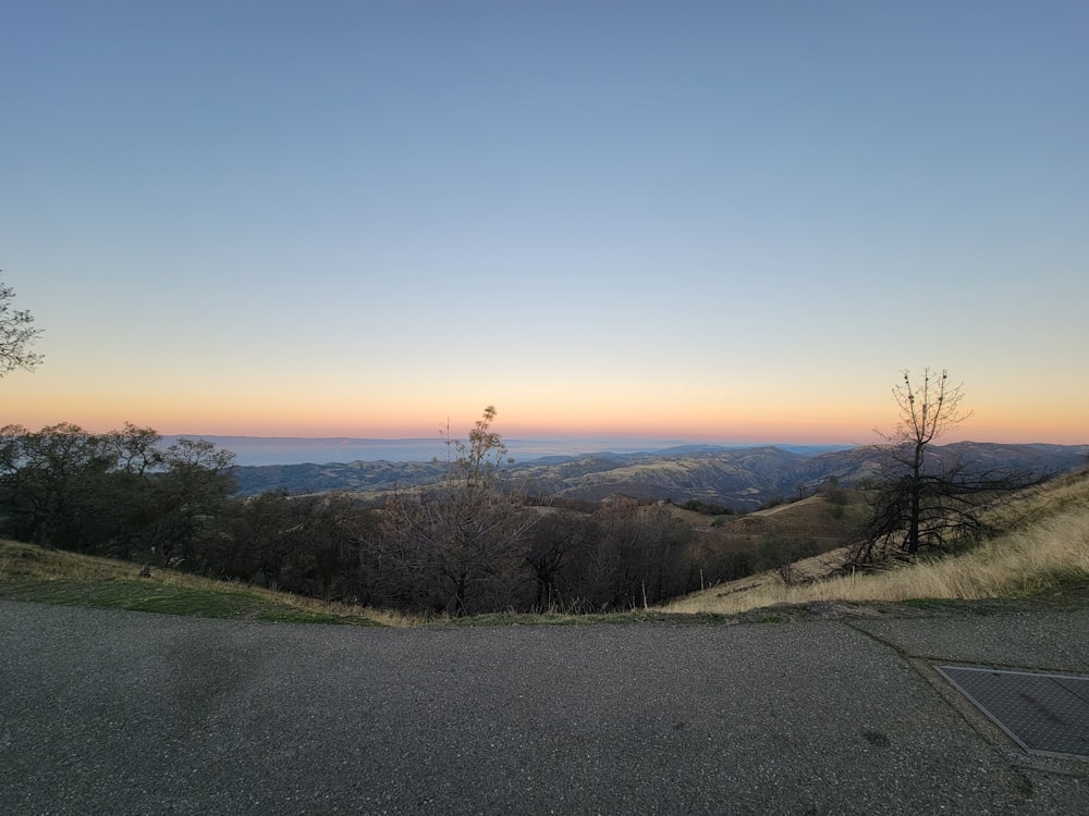 the sun is setting over the mountains in the distance