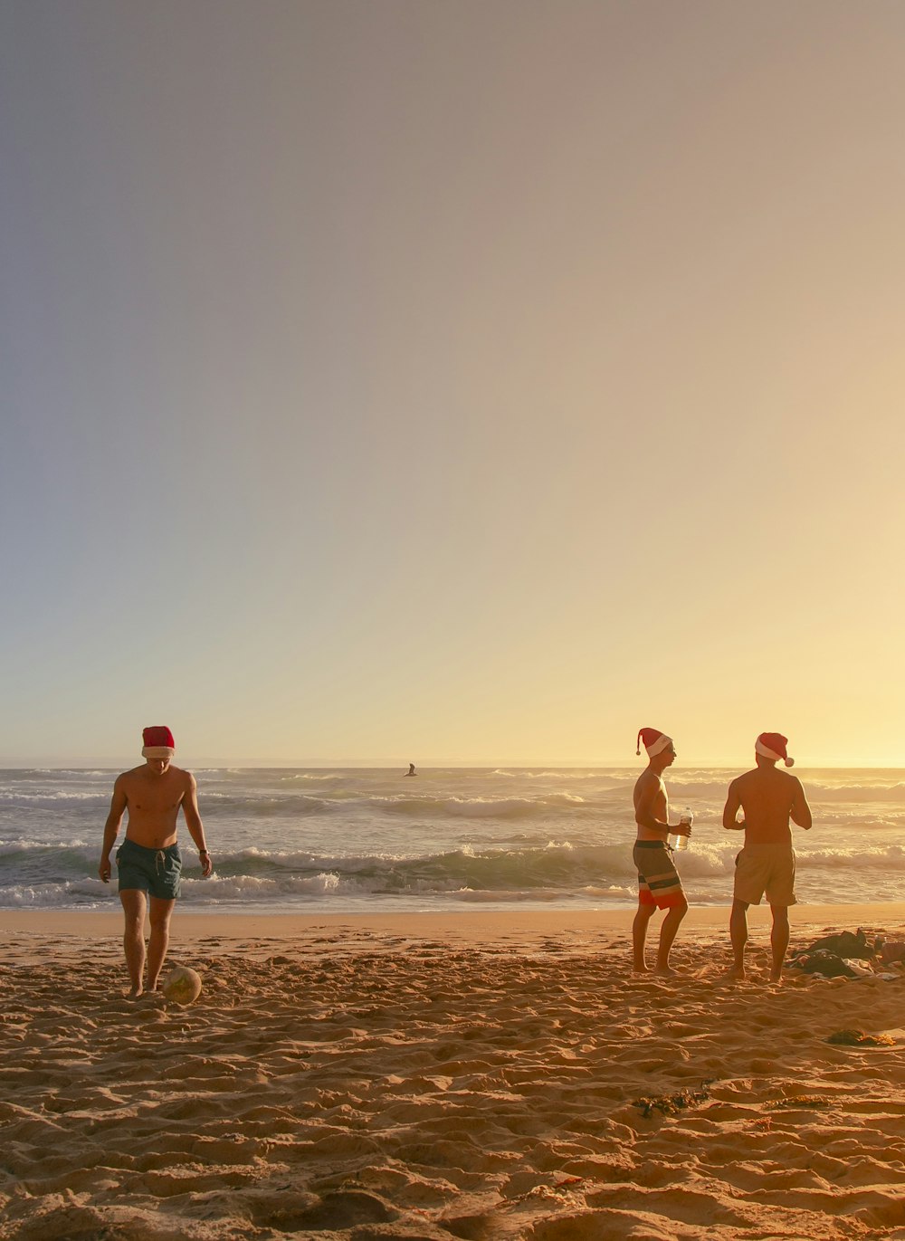 um grupo de pessoas em pé no topo de uma praia de areia