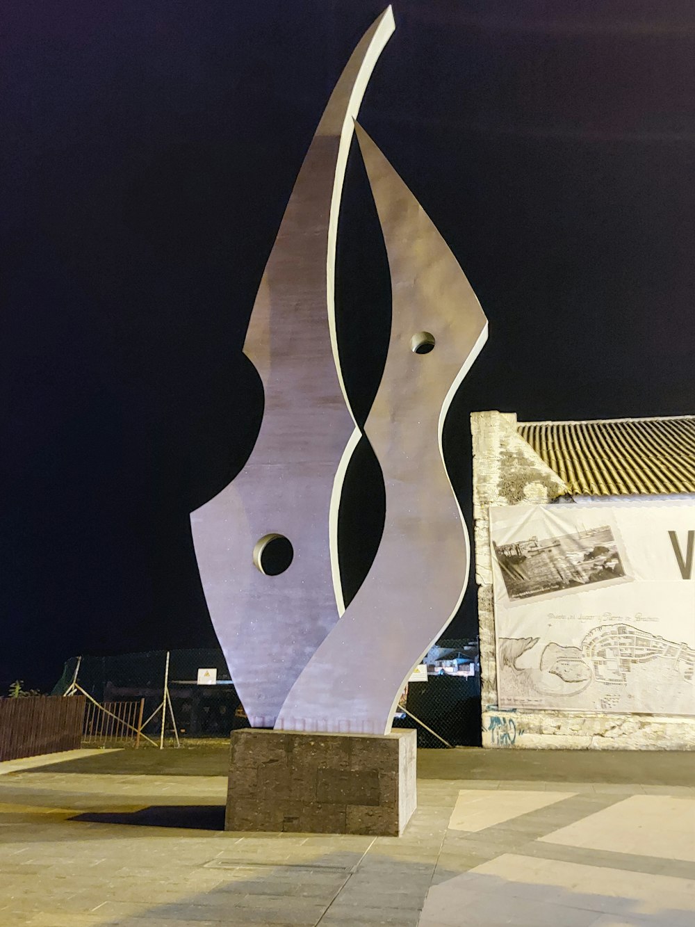 a large metal sculpture sitting on top of a cement slab