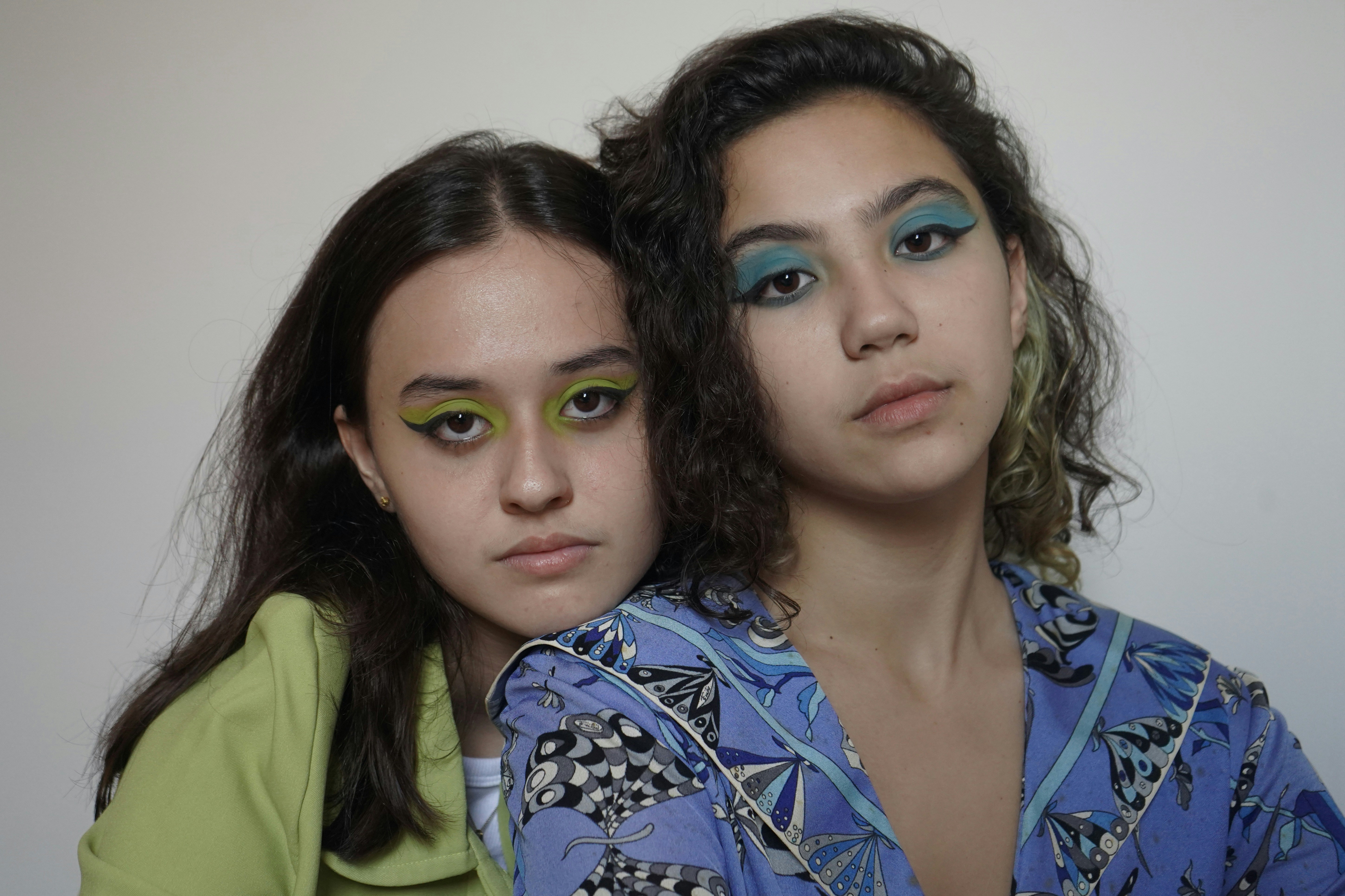 duas mulheres com maquiagem verde e azul em seus rostos