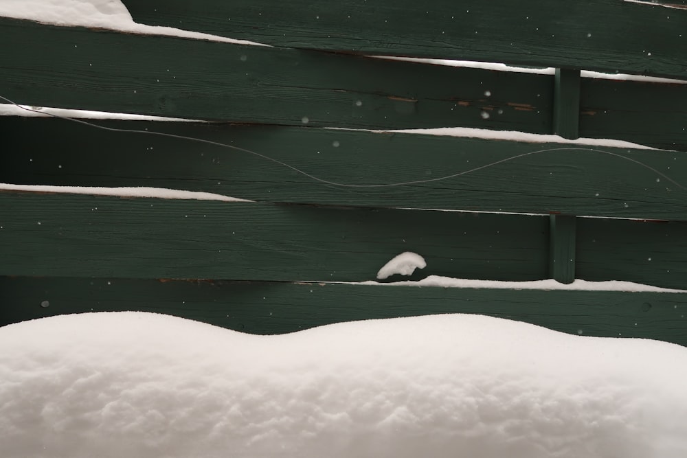 a bird is sitting on a bench in the snow